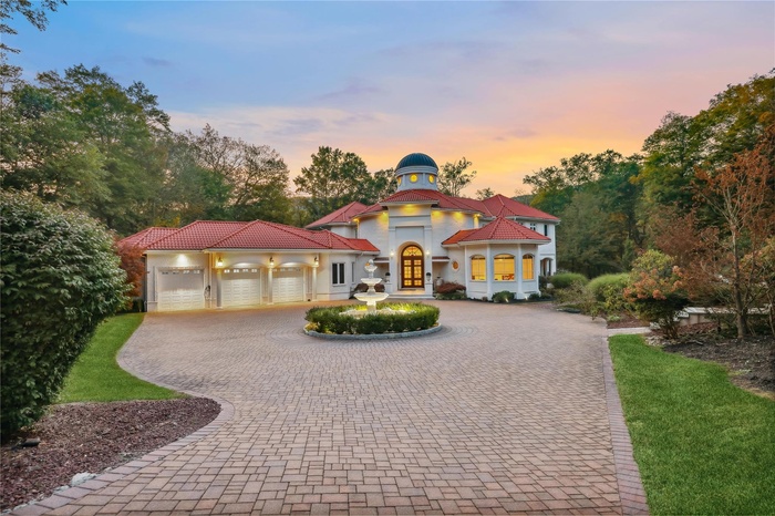 Mediterranean / spanish-style home featuring curved driveway, french doors, a garage, and stucco siding
