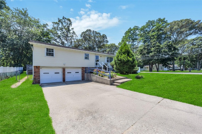 View of front facade with brick siding, a garage, and driveway