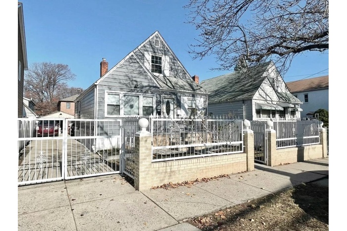 Bungalow-style house with a fenced front yard, a gate, and a chimney