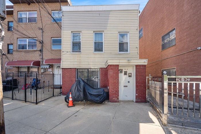Back of house featuring brick siding and fence