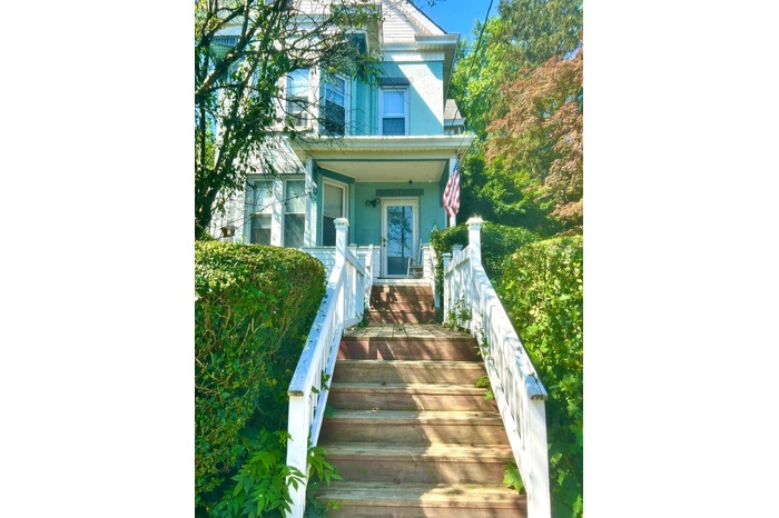 Doorway to property featuring a porch and brick siding
