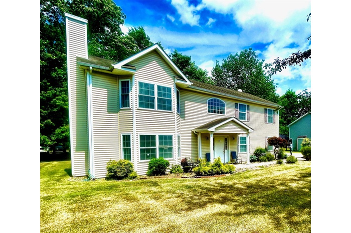 View of front of property with a chimney and a front yard