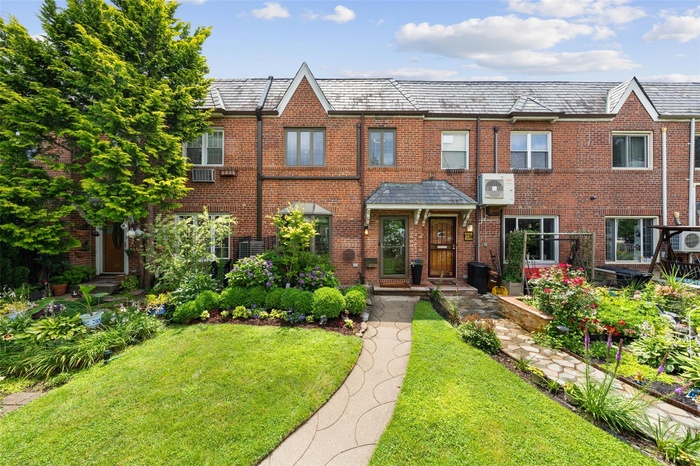 View of front of house with a front yard, brick siding, and a high end roof