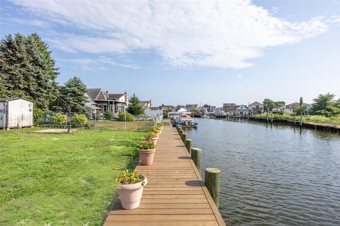 Dock area with a residential view and a water view