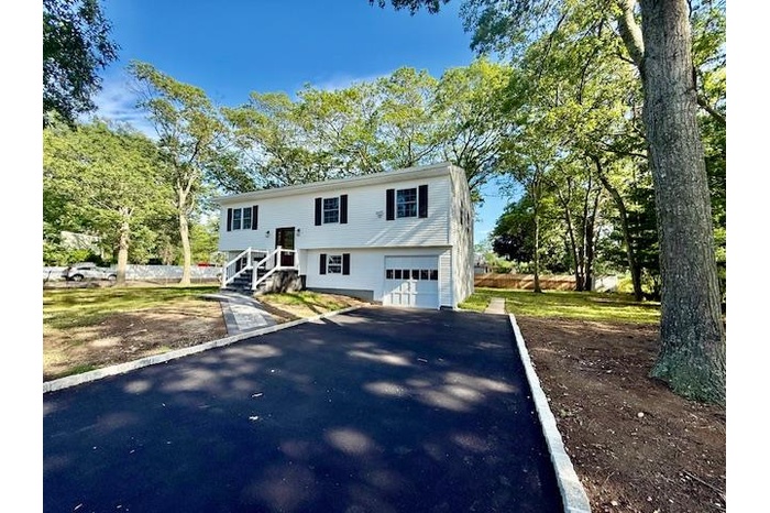 Bi-level home featuring driveway and an attached garage