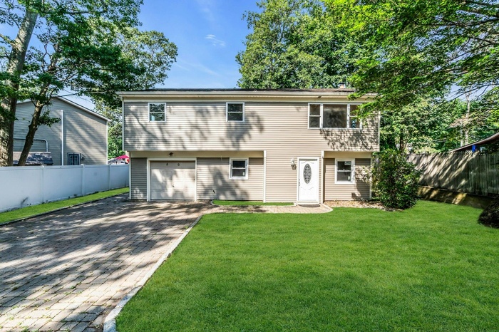 View of front of property featuring a garage and decorative driveway