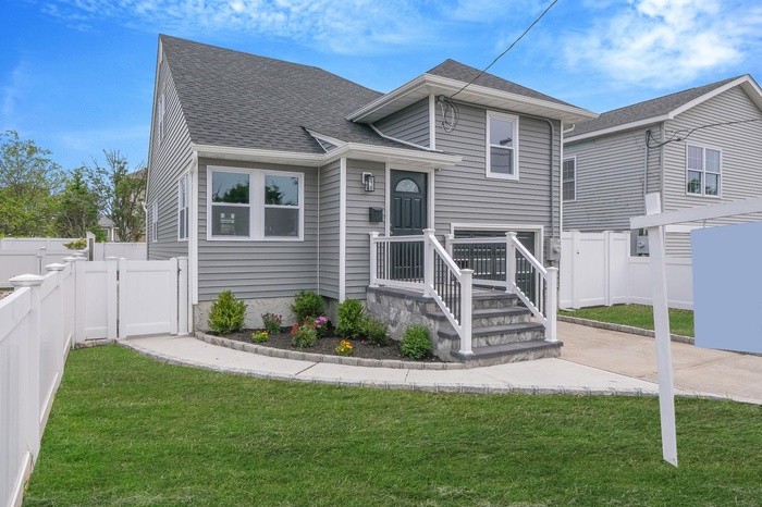Tri-level home featuring roof with shingles, a gate, a fenced backyard, and a patio