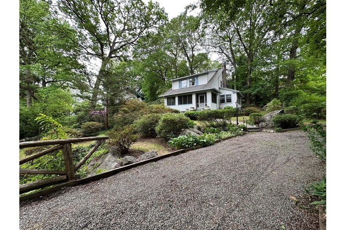 View of front of home featuring gravel driveway