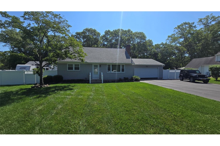 Ranch-style home with driveway, a garage, a chimney, and roof with shingles