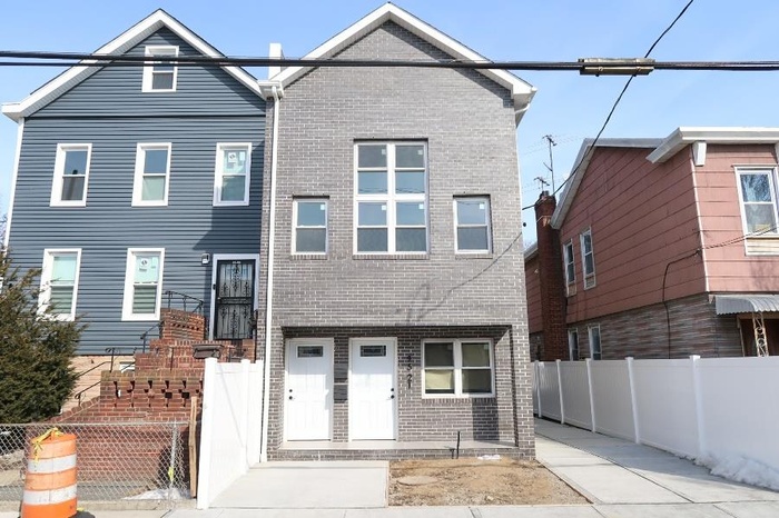 View of front of property featuring a fenced front yard and brick siding