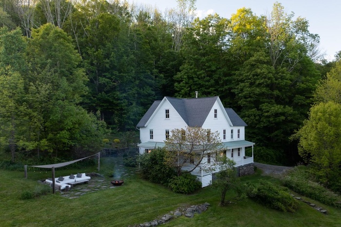View from above of property with a forest, fire pit area