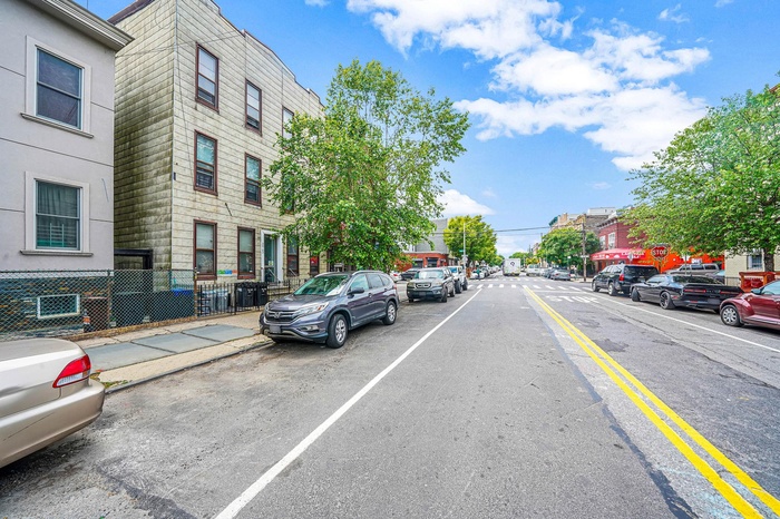 View of asphalt road featuring sidewalks and curbs