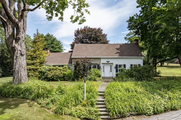 View of front of property with a chimney and roof with shingles