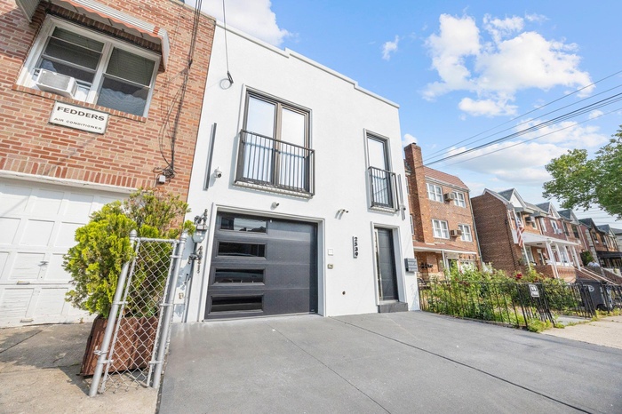 Multi unit property featuring an attached garage, driveway, stucco siding, and cooling unit