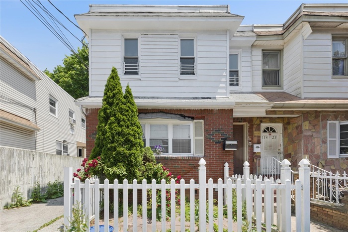 View of front facade with a fenced front yard and brick siding