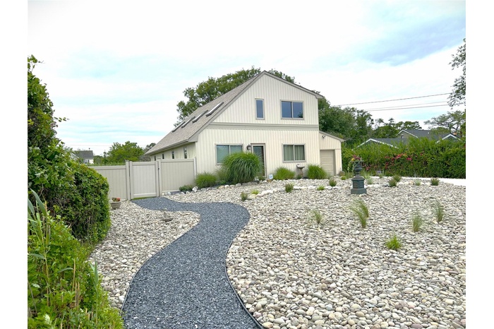 View of side of home featuring a gate and a garage