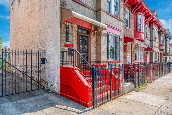 View of exterior entry featuring brick siding and a gate