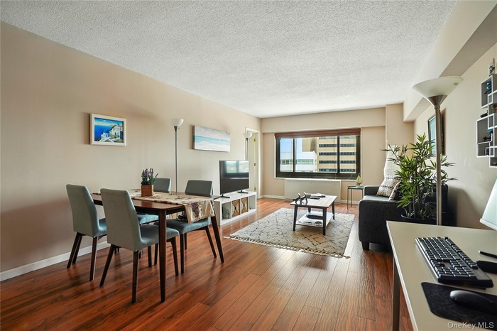 Dining area with wood finished floors, a textured ceiling, and an office area