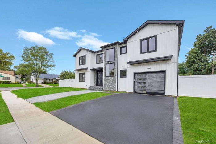 View of front facade with driveway and a garage