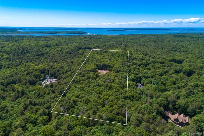 Aerial view of property's location featuring property parcel outlined and a large body of water