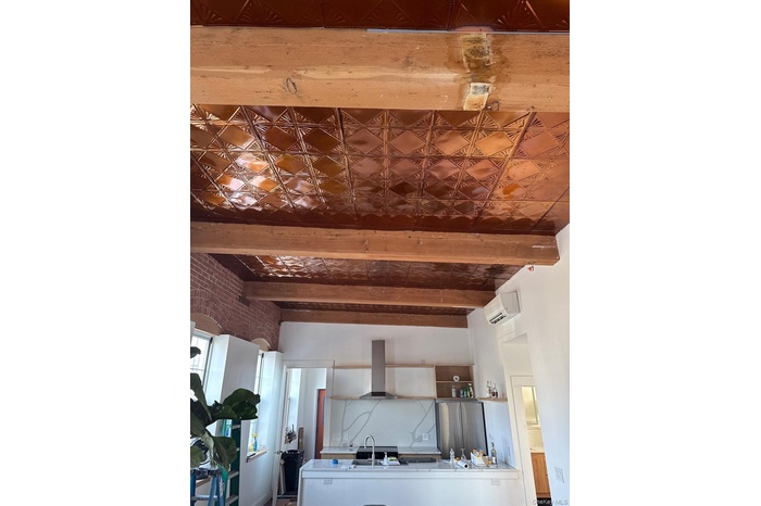 Kitchen featuring an ornate ceiling, freestanding refrigerator, wall chimney exhaust hood, beam ceiling, and an AC wall unit