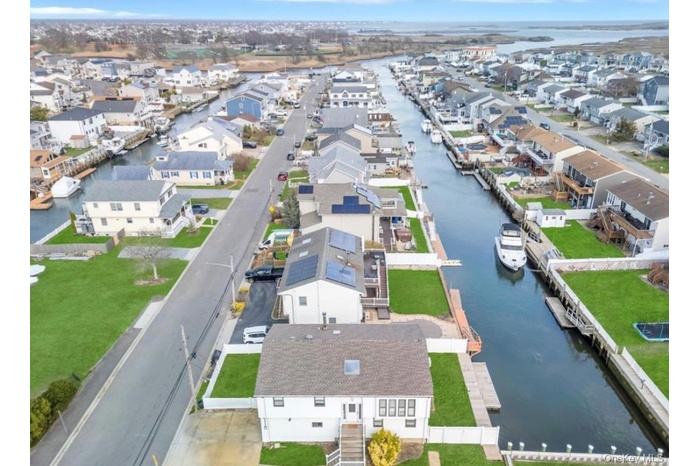 Aerial perspective of suburban area featuring a nearby body of water