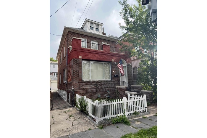 View of front of property featuring brick siding and a fenced front yard
