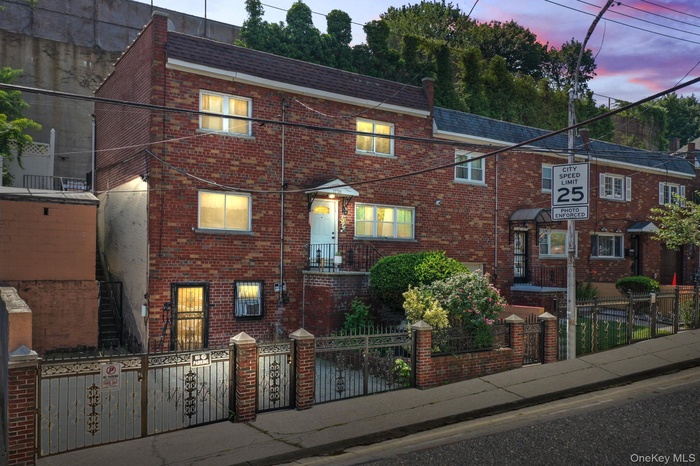 Traditional-style home with brick siding and a fenced front yard