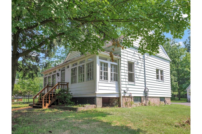 View of property exterior with a lawn