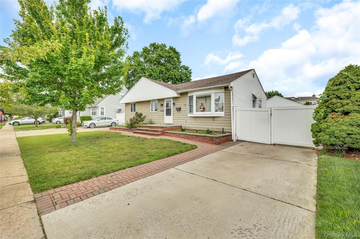 View of front of home featuring a gate and concrete driveway