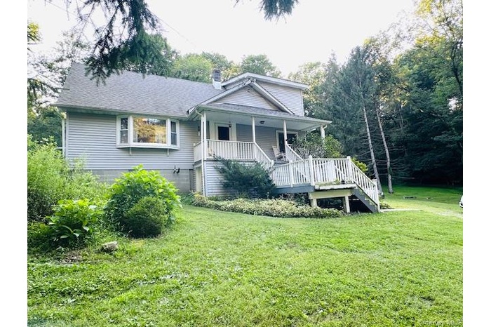 Bungalow-style home featuring stairway, a front lawn, a chimney, and a porch