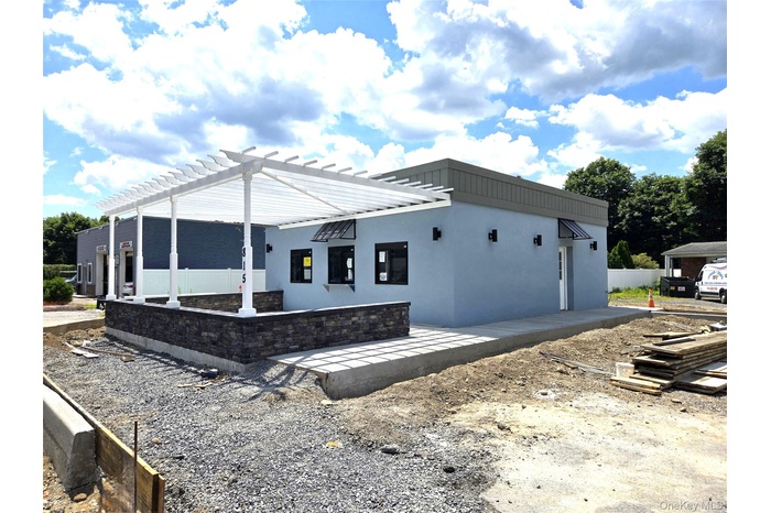 View of home's exterior with stucco siding and a pergola