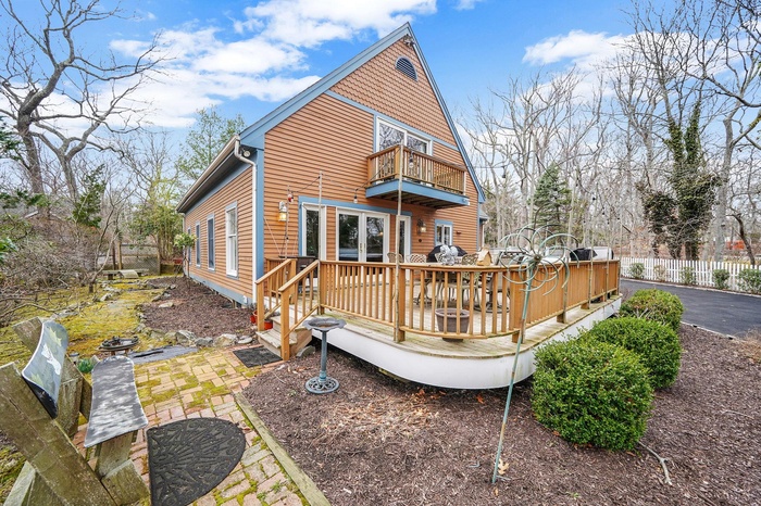 View of Home and Large Driveway with Ample Space for Parking. View of Deck with Hot Tub and Seating. Juliet Balcony Off Second Floor Bedroom. Sliding