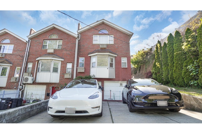 Multi unit property featuring brick siding, a garage, ac unit, and concrete driveway