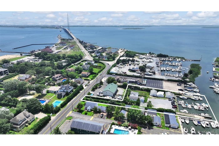 Aerial overview of property's location featuring a nearby body of water, property parcel outlined, and numerous boat docks