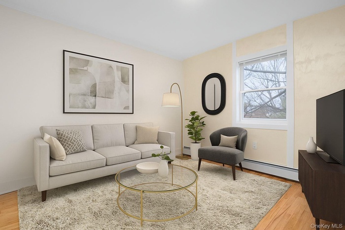 Living area with wood finished floors and baseboard heating