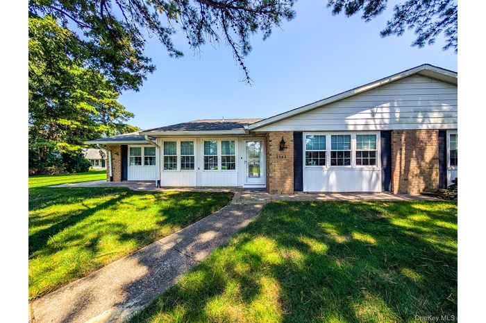 Ranch-style house featuring brick siding and a front lawn