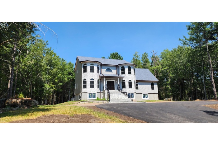 Victorian-style house with a forest view