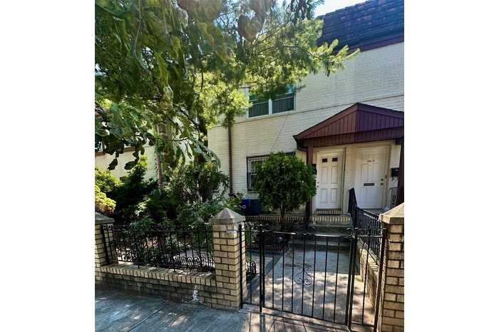 View of front facade featuring a fenced front yard, brick siding, and a gate