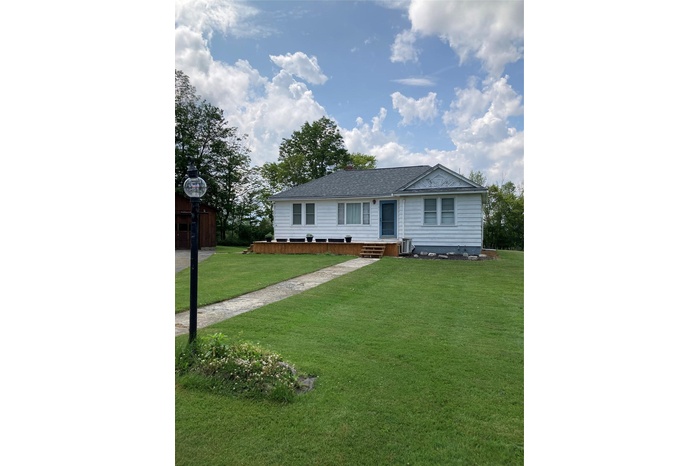 Single story home with roof with shingles and a front yard