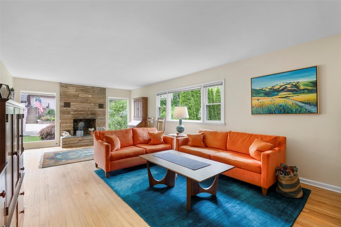 Living area featuring hardwood floors, plenty of natural light, and a fireplace