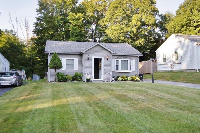 Bungalow-style house with roof with shingles and view of scattered trees