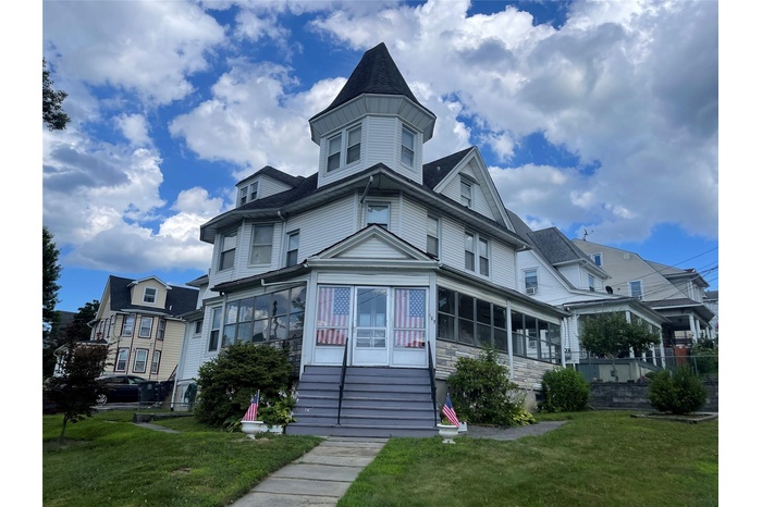 View of front of property with a front yard and entry steps