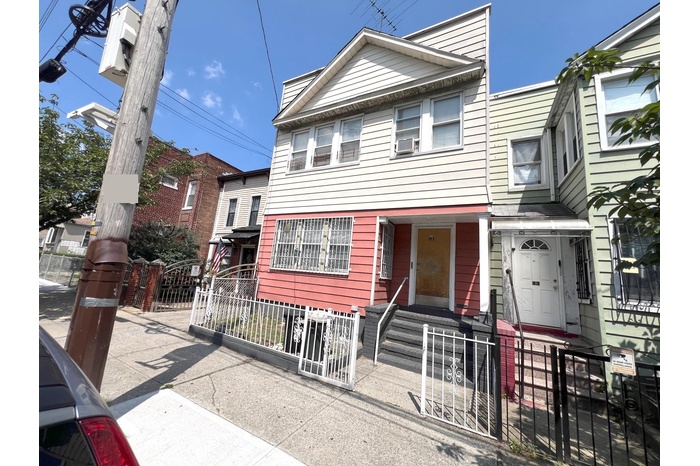 View of front of house featuring a fenced front yard and a gate