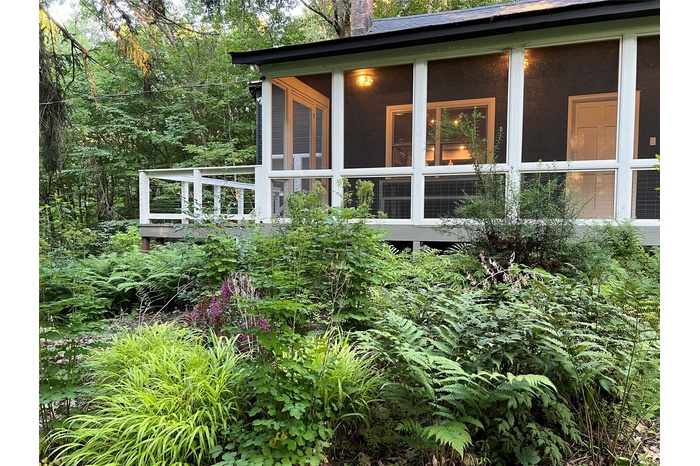 View of side of home featuring a sunroom and a chimney