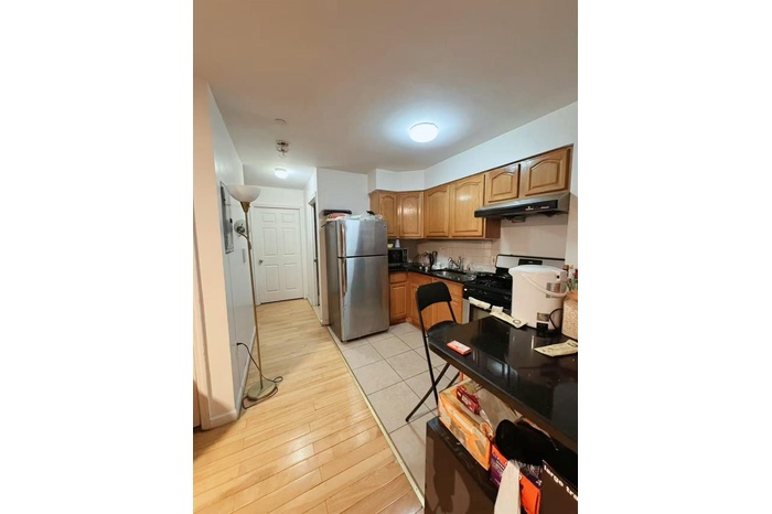 Kitchen featuring freestanding refrigerator, decorative backsplash, gas stove, under cabinet range hood, and dark countertops