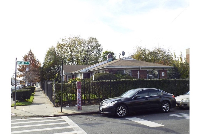 View of front of house featuring brick siding and a chimney