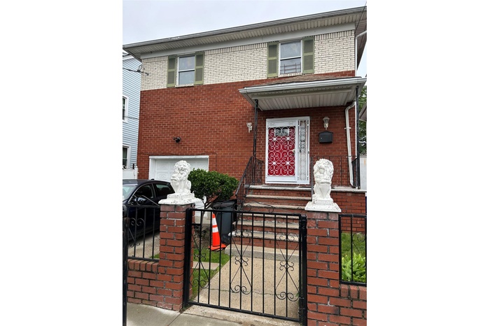 View of front of home featuring brick siding, a fenced front yard, a gate, and a garage