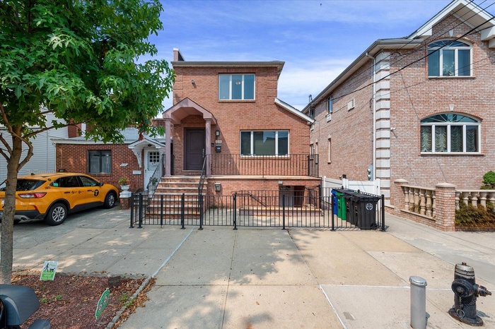 Traditional-style home featuring brick siding and a gate
