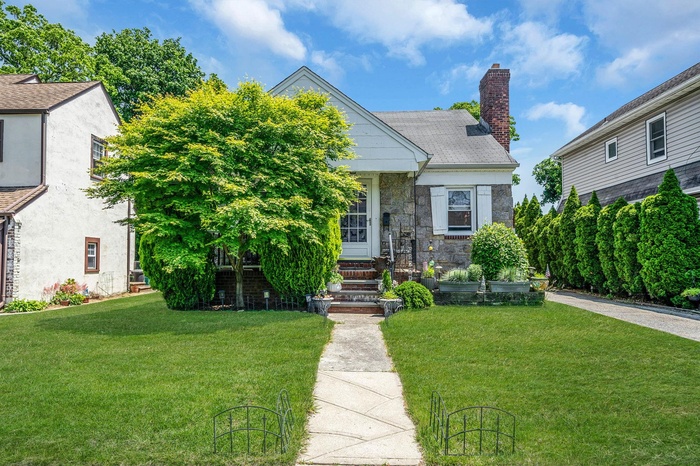 View of front of property featuring a front yard and a chimney